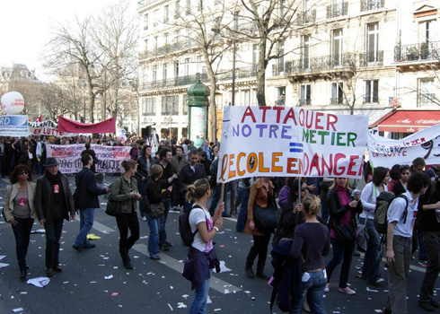 Student teachers. The banner says, "To attack our profession means schools are in danger."