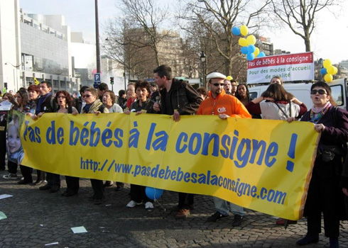 Day care workers protesting layoffs. Their sign could be translated as "Don't put babies in storage lockers."